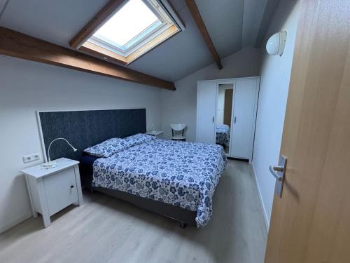 a bedroom with a bed and a skylight at De Paer - Hof van Libeek in Sint Geertruid