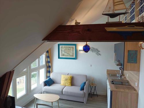 a living room with a couch and a table at L'envol du Goéland in Le Croisic