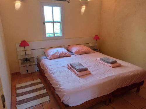 - une chambre avec un lit avec deux oreillers et une fenêtre dans l'établissement Maisonnette dans mas authentique avec piscine, à Saint-Laurent-dʼAigouze