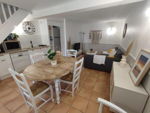 une cuisine et un salon avec une table et un canapé dans l'établissement Maisonnette dans mas authentique avec piscine, à Saint-Laurent-dʼAigouze