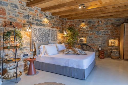 a bedroom with a bed in a brick wall at Harmony Luxury Villas Naxos in Kastraki Naxou