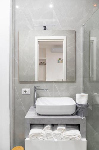 a bathroom with a white sink and a mirror at La Corte Guest House in Bari