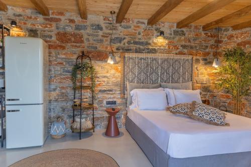 a bedroom with a bed and a brick wall at Harmony Luxury Villas Naxos in Kastraki Naxou
