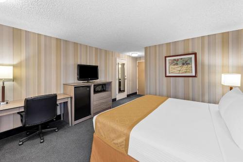 a hotel room with a bed and a desk and a television at Best Western Cascadia Inn in Everett