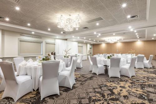 a banquet room with white tables and white chairs at Prestige Lakeside Resort, WorldHotels Elite in Nelson