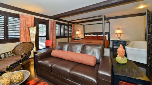 a bedroom with a couch and a bed and a tub at Prestige Lakeside Resort, WorldHotels Elite in Nelson