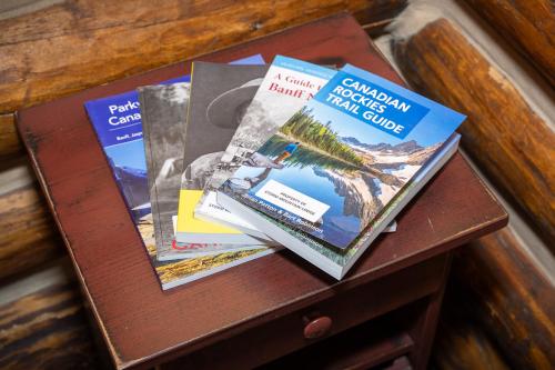three books sitting on top of a wooden table at Storm Mountain Lodge & Cabins in Banff