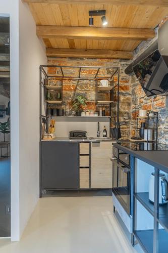 a kitchen with a stone wall at Harmony Luxury Villas Naxos in Kastraki Naxou