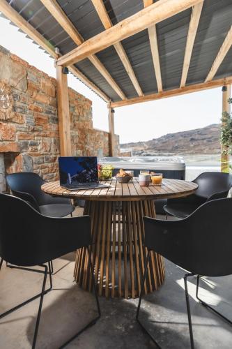 a patio with a table with a laptop on it at Harmony Luxury Villas Naxos in Kastraki Naxou
