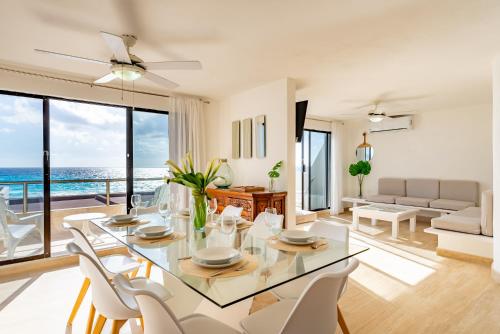 a living room with a glass table and white chairs at Beachfront Villa in Cancun Hotel Zone in Cancún