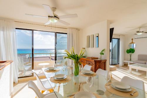 a dining room with a table and chairs and the ocean at Beachfront Villa in Cancun Hotel Zone in Cancún