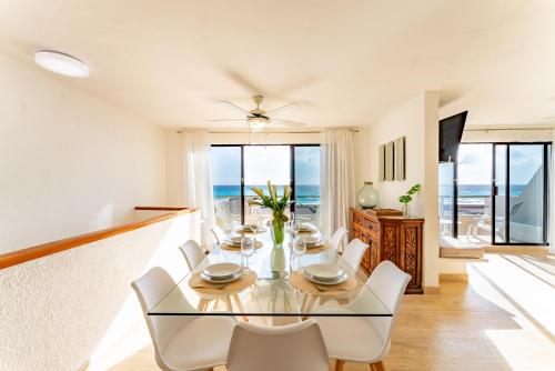 a dining room with a glass table and white chairs at Beachfront Villa in Cancun Hotel Zone in Cancún