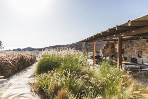 a patio with a wooden pergola and some plants at Harmony Luxury Villas Naxos in Kastraki Naxou