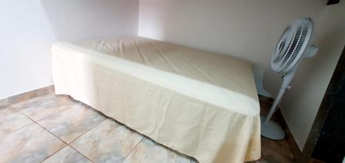 a bed in a room with a fan at Three A Diárias in Mata de Sao Joao