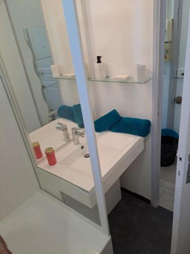 une salle de bain avec un lavabo blanc et un miroir dans l'établissement 19eme studio, à Paris