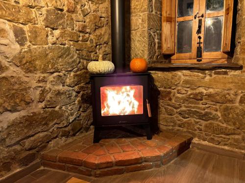 a stone fireplace in a stone wall with a stove at Casa Milu in Armiello