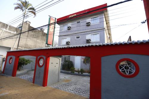 a building with a red and white building with a garage at Hotel Park Leste, São Paulo in Sao Paulo