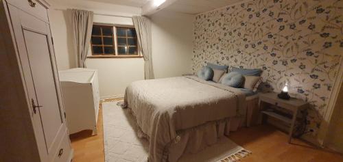 a bedroom with a bed with blue pillows on it at Hus på hästgård, Söderåsen! in Slättåkra