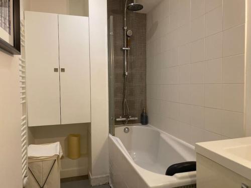 une salle de bain blanche avec une baignoire et un lavabo dans l'établissement Au Milieu des Arbres, à Suresnes