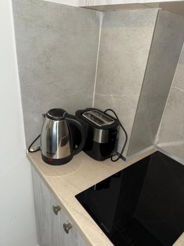 a tea pot and kettle on a counter in a kitchen at STAY-FIVE rooms & apartments in Shkodër