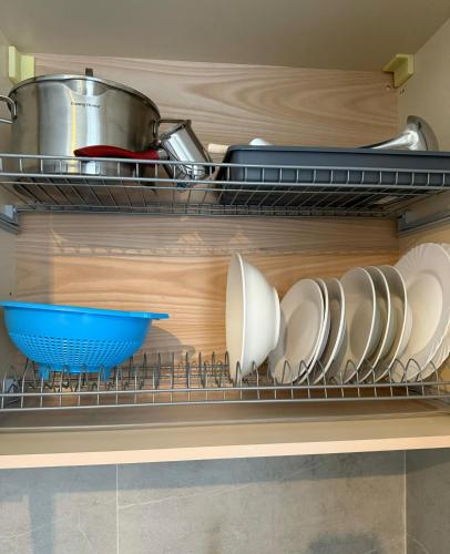 a shelf with plates and bowls on it in a kitchen at STAY-FIVE rooms & apartments in Shkodër