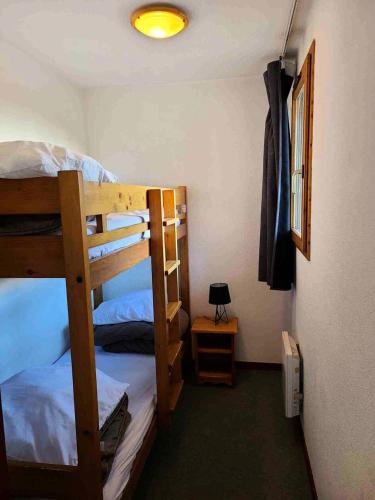 une chambre avec deux lits superposés et une lampe dans l'établissement Résidence Le Cheval Blanc - Studio pour 4 Personnes 193124, à Modane