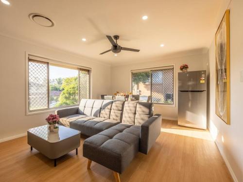 a living room with a couch and a refrigerator at Super Value 4BR House near Westfield Shops and Parks in Brisbane