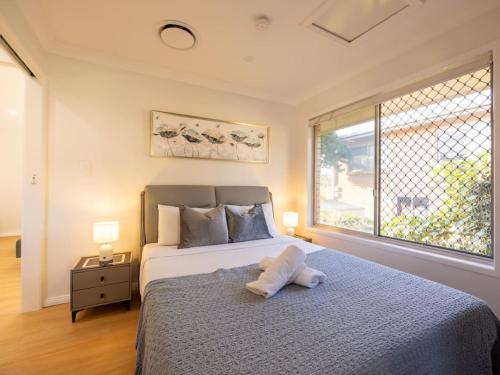 a bedroom with a bed with a stuffed animal on it at Super Value 4BR House near Westfield Shops and Parks in Brisbane