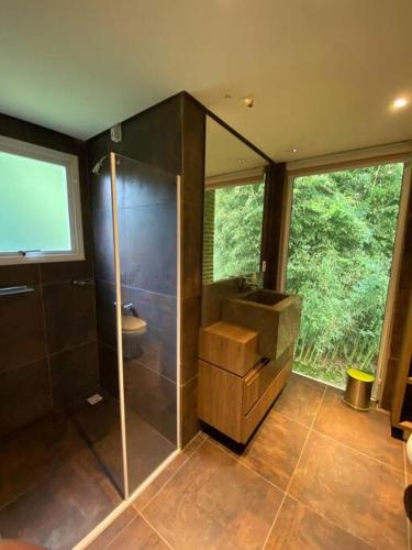 een badkamer met een glazen douche en een wastafel bij Sitio Entre Rios in Guaporé