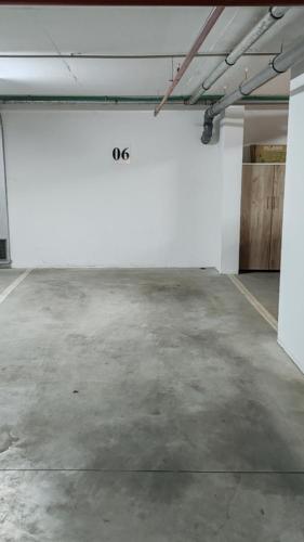 an empty parking lot with a white wall in a garage at Apartman Max in Modriča