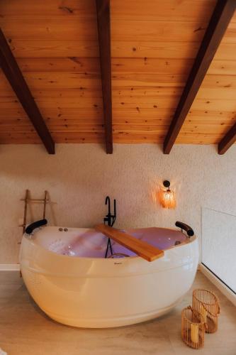 a large white bath tub in a room with wooden ceilings at DD's Roof Villas in Ardeşen