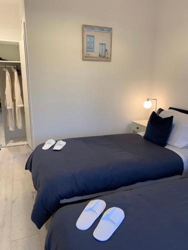 a bedroom with two beds with slippers on them at Beach Row in Wexford
