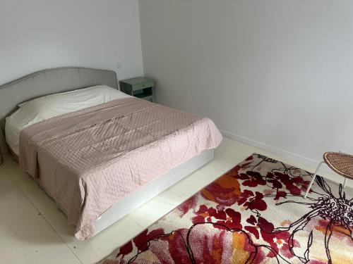 une chambre avec un lit et un tapis au sol dans l'établissement Le mazet, à Pélissanne