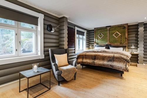 a bedroom with a bed and a chair and a table at Hemsedal Mountain Retreat in Hemsedal