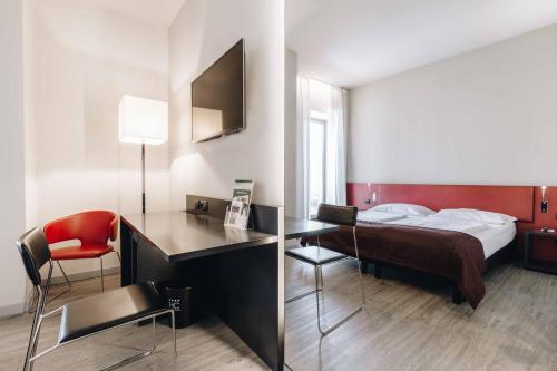 Pokój hotelowy z łóżkiem i biurkiem w obiekcie Hotel Continental w mieście Cremona