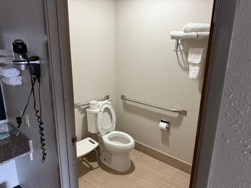 a bathroom with a toilet and a phone in it at Days Inn by Wyndham Muncie -Ball State University in Muncie