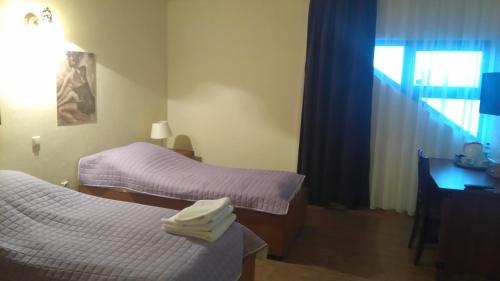 a room with two beds and a desk and a window at Karczma Biesiadna in Dalnia