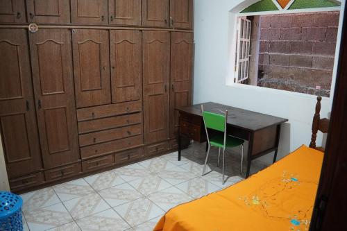 ディアマンティーナにあるCasa em Diamantina-MGのデスク、テーブル、ベッドが備わる客室です。