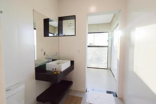 a bathroom with a sink and a mirror at Entre Serras & Águas in Capitólio
