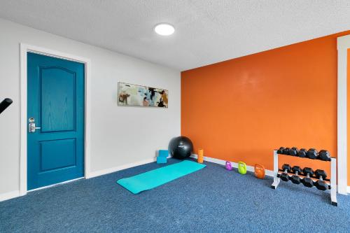 a room with a gym with a door and weights at Oasis 105 - Blue Bliss in Titusville