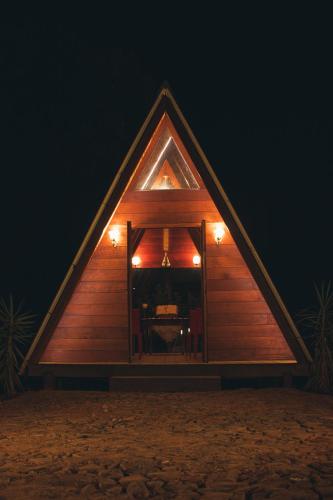 a small wooden house with a window in the night at Entre Serras & Águas in Capitólio