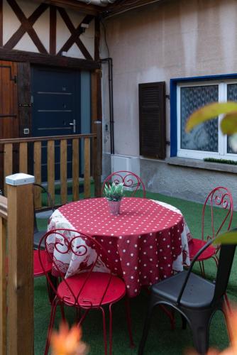 une table et des chaises rouges avec un chiffon de table rouge et blanc à la polka dans l'établissement Effet Mer, 4 etoiles, gîte de 80m2, à Dorlisheim