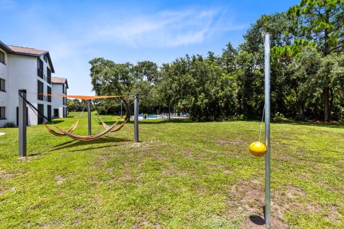 an empty park with a swing in the grass at Oasis 219 - Amalfi Allure in Titusville