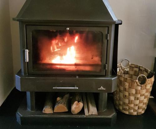 a stove with a fire in it with a basket at Cerca del Puente Tibetano I Tríplex con Vistas in Canillo