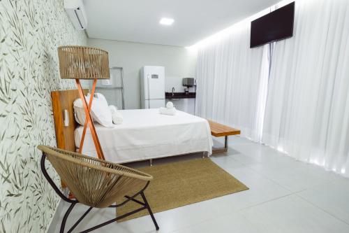 a bedroom with a bed and a chair in a room at Entre Serras & Águas in Capitólio