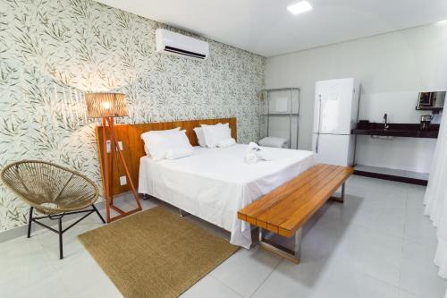 a bedroom with a bed and a table and a refrigerator at Entre Serras & Águas in Capitólio
