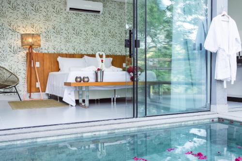 a bedroom with a bed and a swimming pool at Entre Serras & Águas in Capitólio