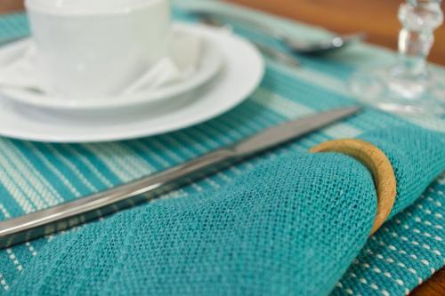 a blue table cloth with a knife and plates on it at Entre Serras & Águas in Capitólio
