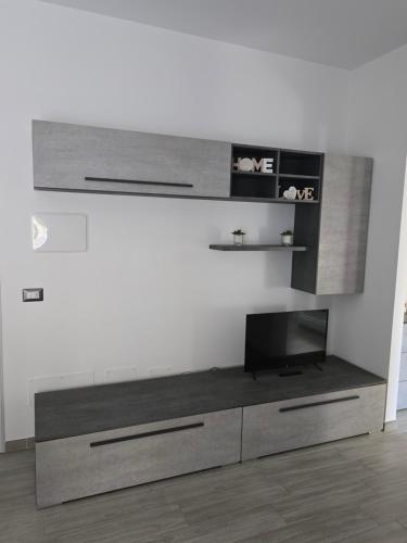 a living room with a tv on a wall at Deluxe apartment Fiumicino near airport, free parking in Isola Sacra