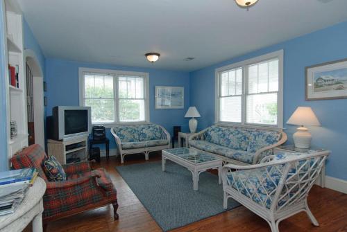 a living room with blue walls and furniture at Craft Upper Unit by Bryant Real Estate in Wrightsville Beach